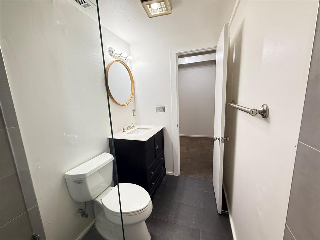 3129 Ross Avenue, Unit 5 Dallas, TX 75204 - Photo 4 of 8 a bathroom with a toilet a sink and a mirror