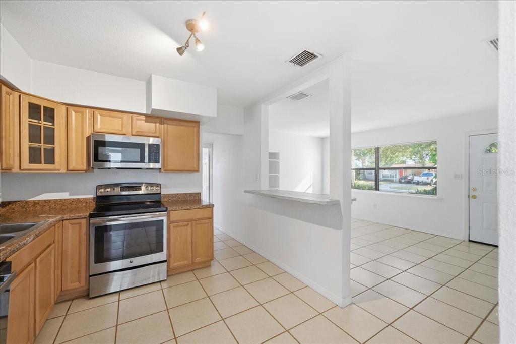 10971 57th Avenue Seminole, FL 33772 - Photo 11 of 26 a kitchen with granite countertop a stove and a microwave