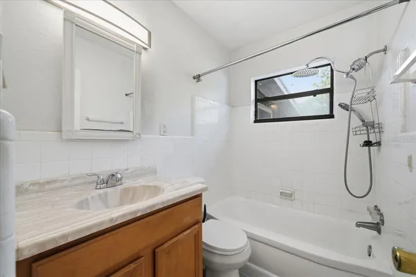 a bathroom with a granite countertop sink a toilet and shower