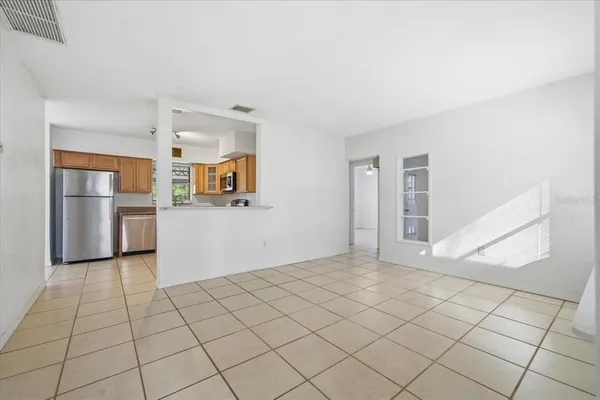 a view of a kitchen with a sink and an empty room