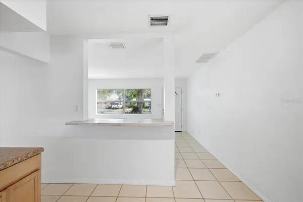 a view of a hallway with wooden floor and a large window
