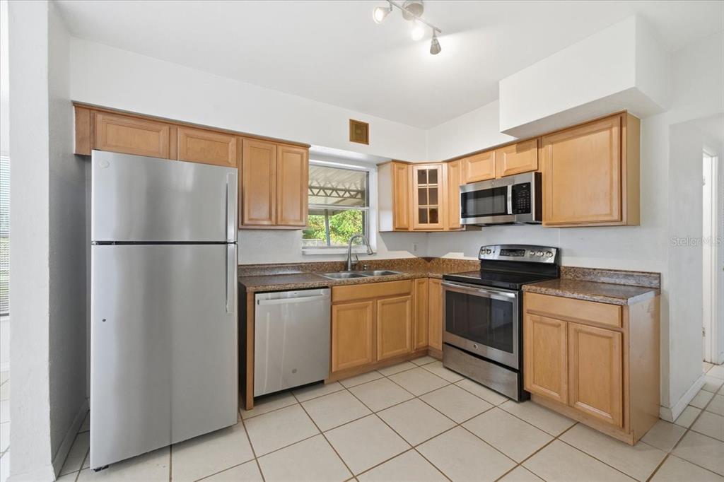 10971 57th Avenue Seminole, FL 33772 - Photo 7 of 26 a kitchen with stainless steel appliances granite countertop a refrigerator sink and stove
