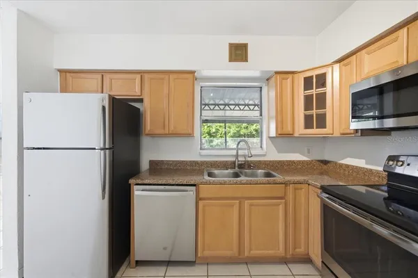 a kitchen with stainless steel appliances granite countertop a refrigerator sink and stove