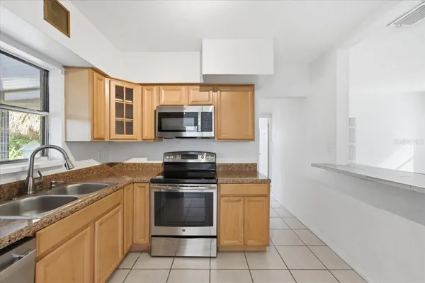 a kitchen with granite countertop a sink stainless steel appliances and cabinets