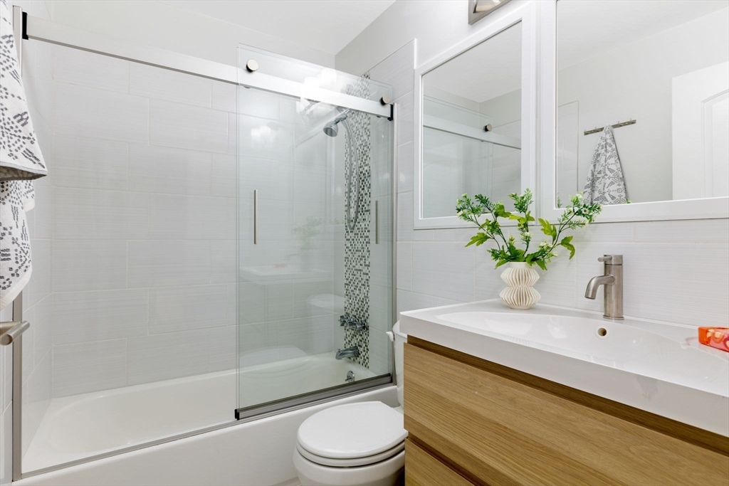 910 Edgell Road, Unit 914A Framingham, MA 01701 - Photo 16 of 22 a bathroom with a shower sink vanity mirror and toilet