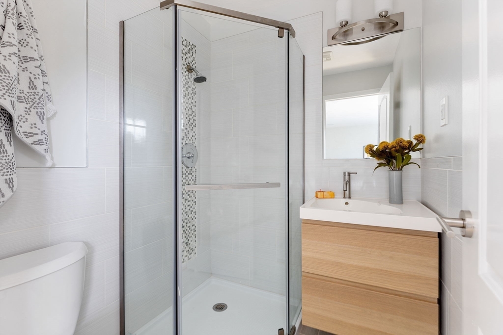910 Edgell Road, Unit 914A Framingham, MA 01701 - Photo 18 of 22 a bathroom with a shower sink and mirror