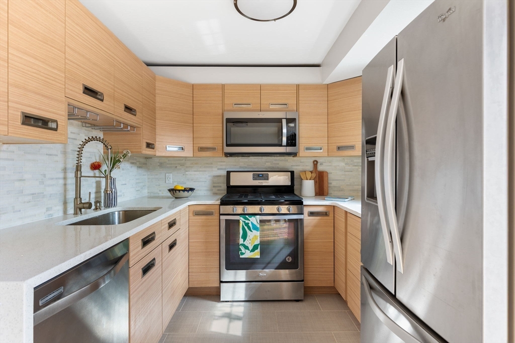 910 Edgell Road, Unit 914A Framingham, MA 01701 - Photo 7 of 22 a kitchen with stainless steel appliances a stove a microwave and a refrigerator