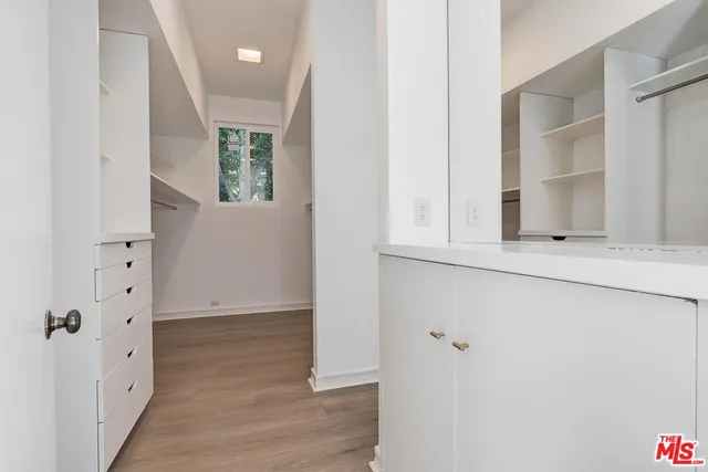 an entryway with wooden floor and cabinet
