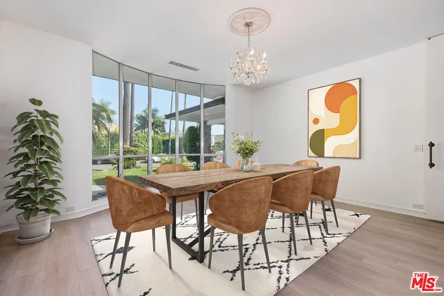 a dining room with furniture a chandelier and wooden floor