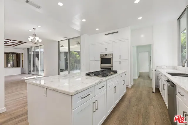 a kitchen with granite countertop a sink stove and cabinets
