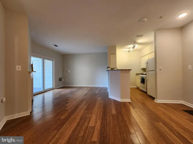 a view of a kitchen with wooden floor and a refrigerator