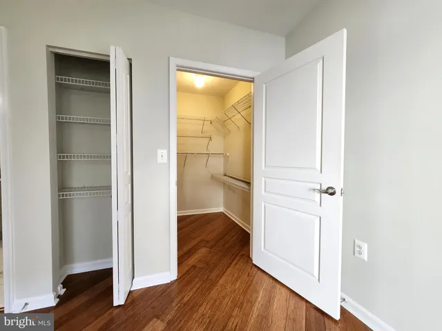 a view of empty room with wooden floor and wall