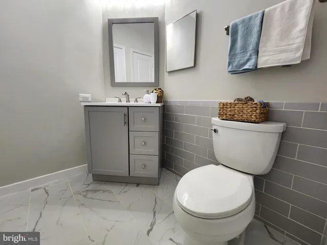 a bathroom with a toilet a sink and mirror