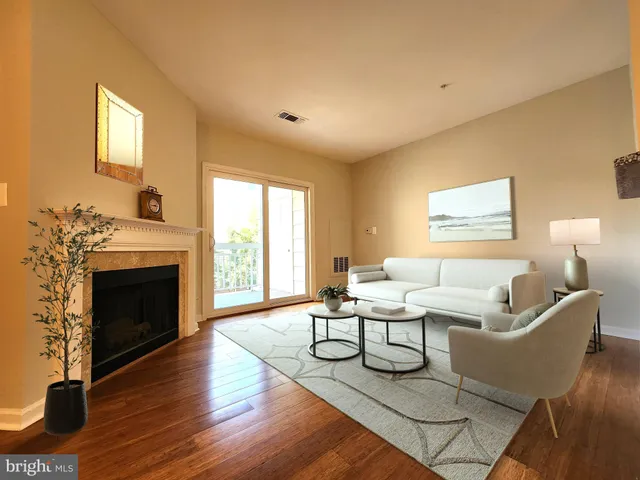 a living room with furniture a fireplace and a large window