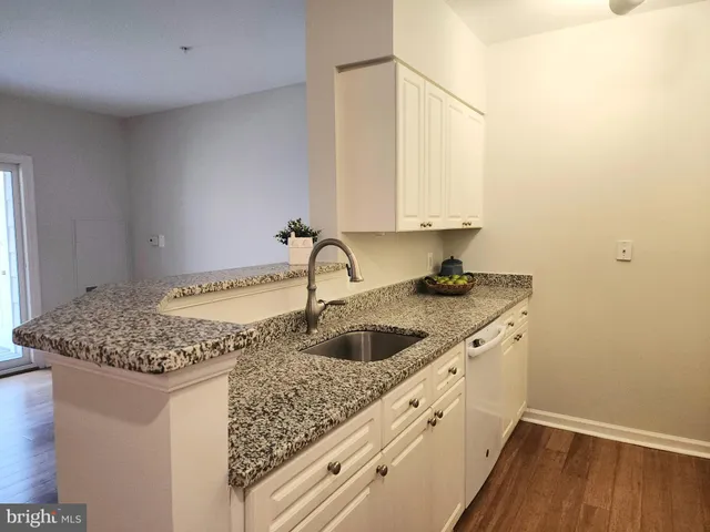 a kitchen with a granite countertop sink and cabinets
