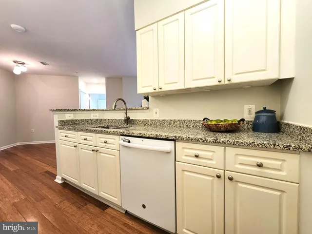 a kitchen with granite countertop white cabinets and white appliances