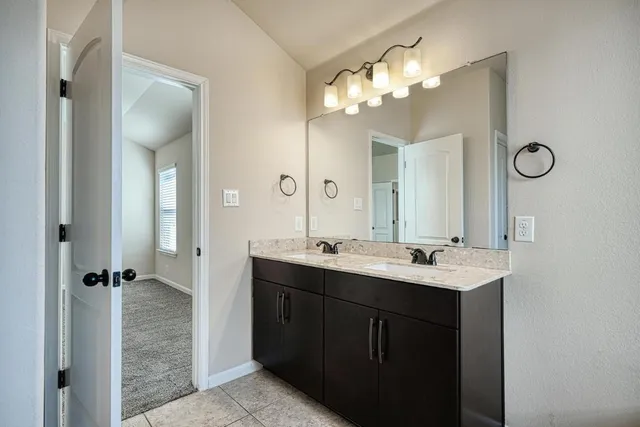 a bathroom with a double vanity sink mirror and shower