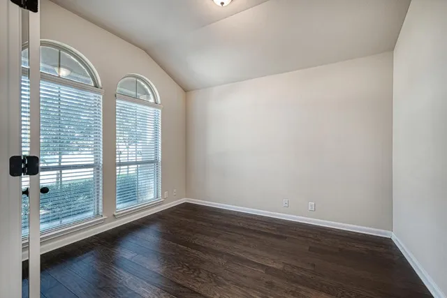 a view of a livingroom with wooden floor and windows