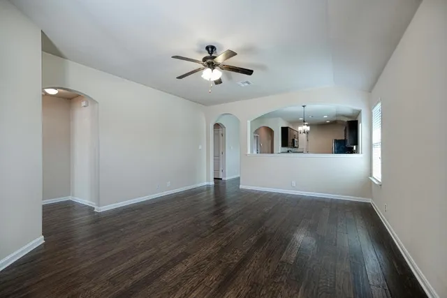 a view of a livingroom with wooden floor and a ceiling fan