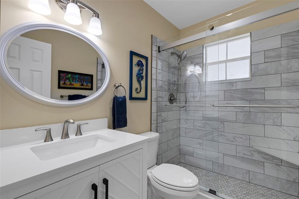 1977 Beach Road, Unit 84 Englewood, FL 34223 - Photo 18 of 42 a bathroom with a sink mirror vanity and toilet