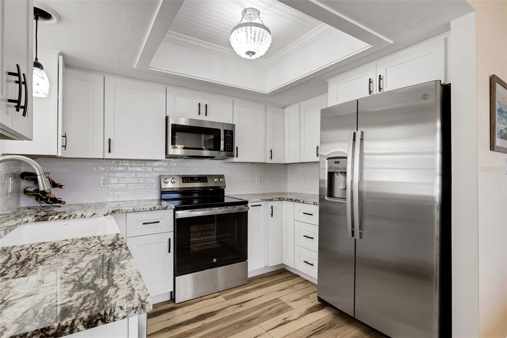 1977 Beach Road, Unit 84 Englewood, FL 34223 - Photo 3 of 42 a kitchen with stainless steel appliances granite countertop a refrigerator a stove a sink and a microwave