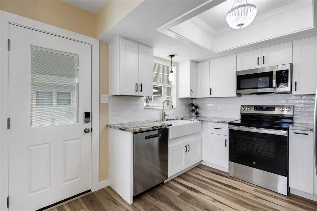 1977 Beach Road, Unit 84 Englewood, FL 34223 - Photo 7 of 42 a kitchen with stainless steel appliances granite countertop a stove and a microwave