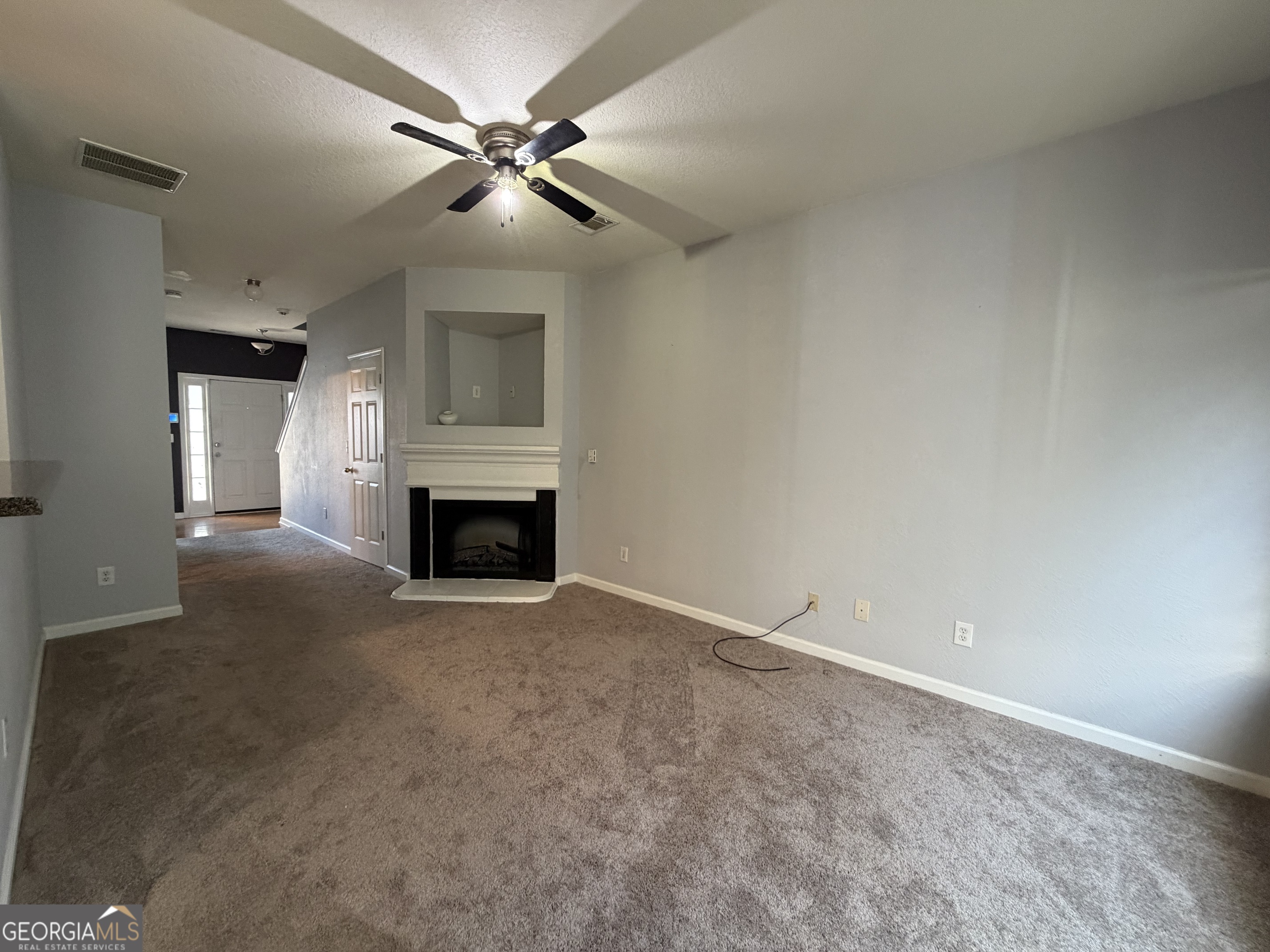 2807 Snapfinger Manor Decatur, GA 30035 - Photo 6 of 17 an empty room with fireplace and fan