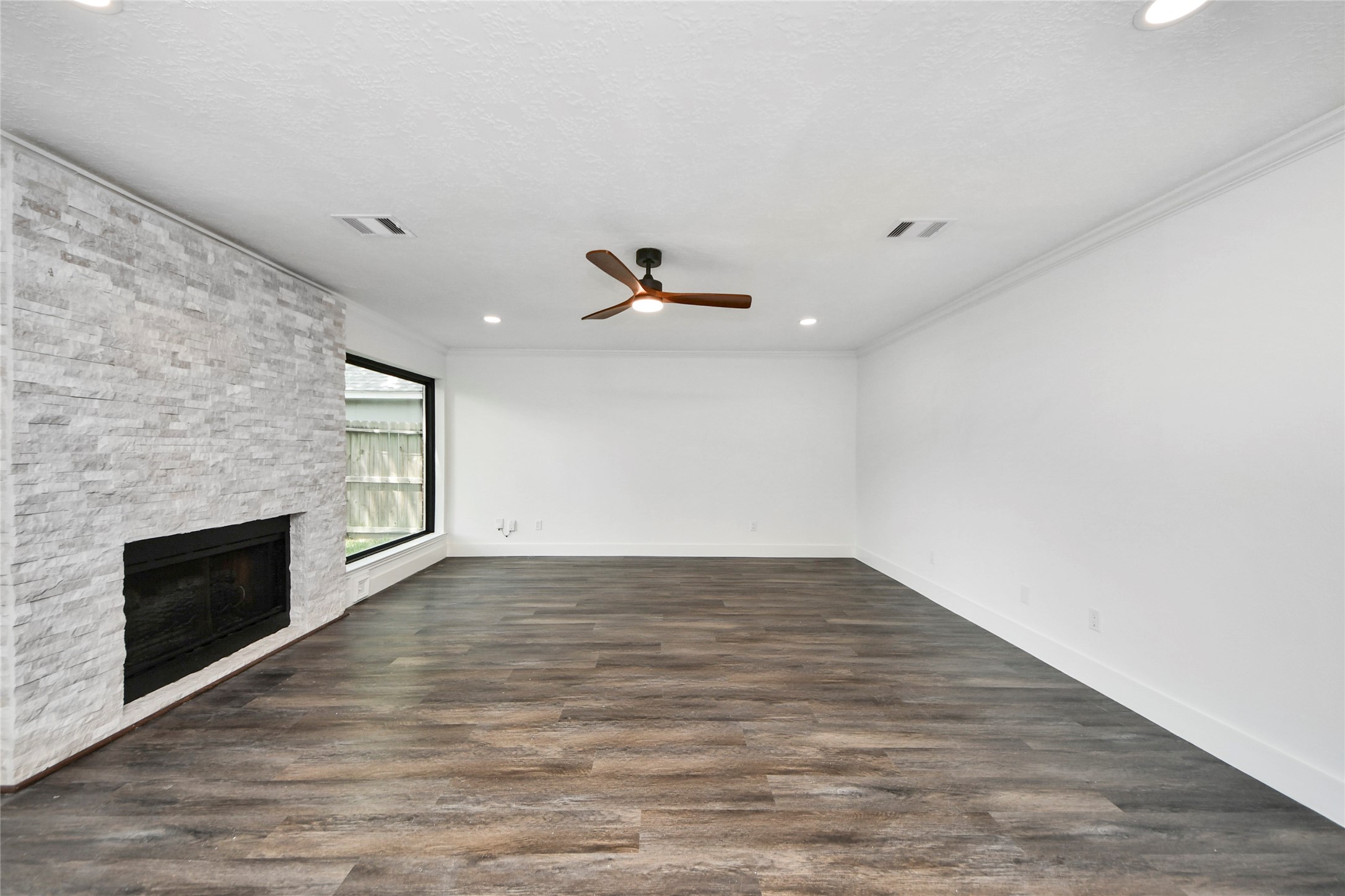8510 Canyon Pine Drive Spring, TX 77379 - Photo 14 of 42 an empty room with wooden floor fireplace and windows