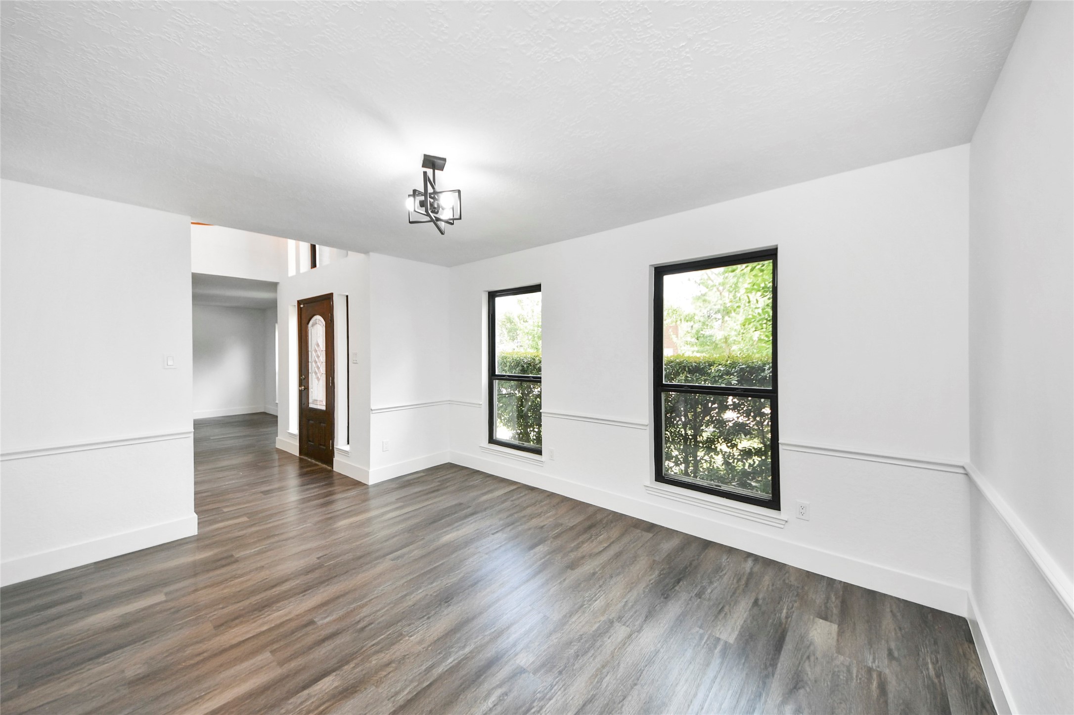 8510 Canyon Pine Drive Spring, TX 77379 - Photo 17 of 42 an empty room with wooden floor chandelier and windows