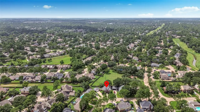 an aerial view of residential houses with city and green space
