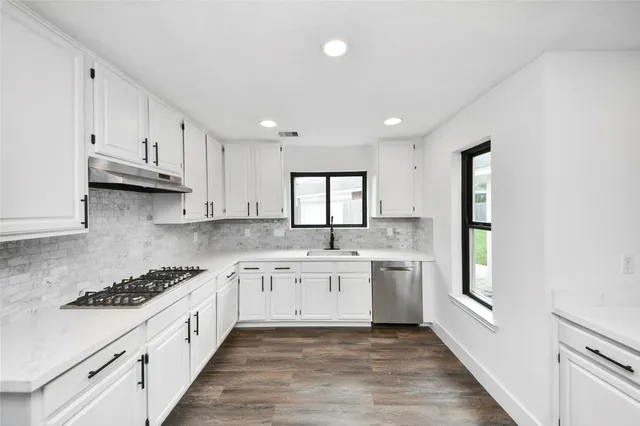a large kitchen with stainless steel appliances granite countertop a stove and a sink
