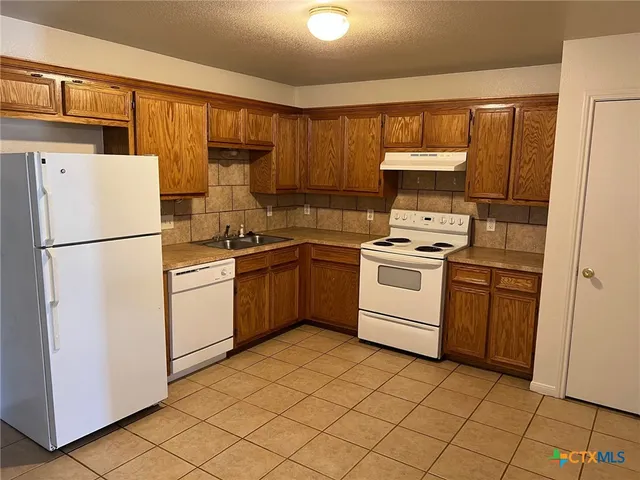 a kitchen with a stove sink and a refrigerator