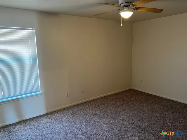 a view of a small space with wooden floor and a window