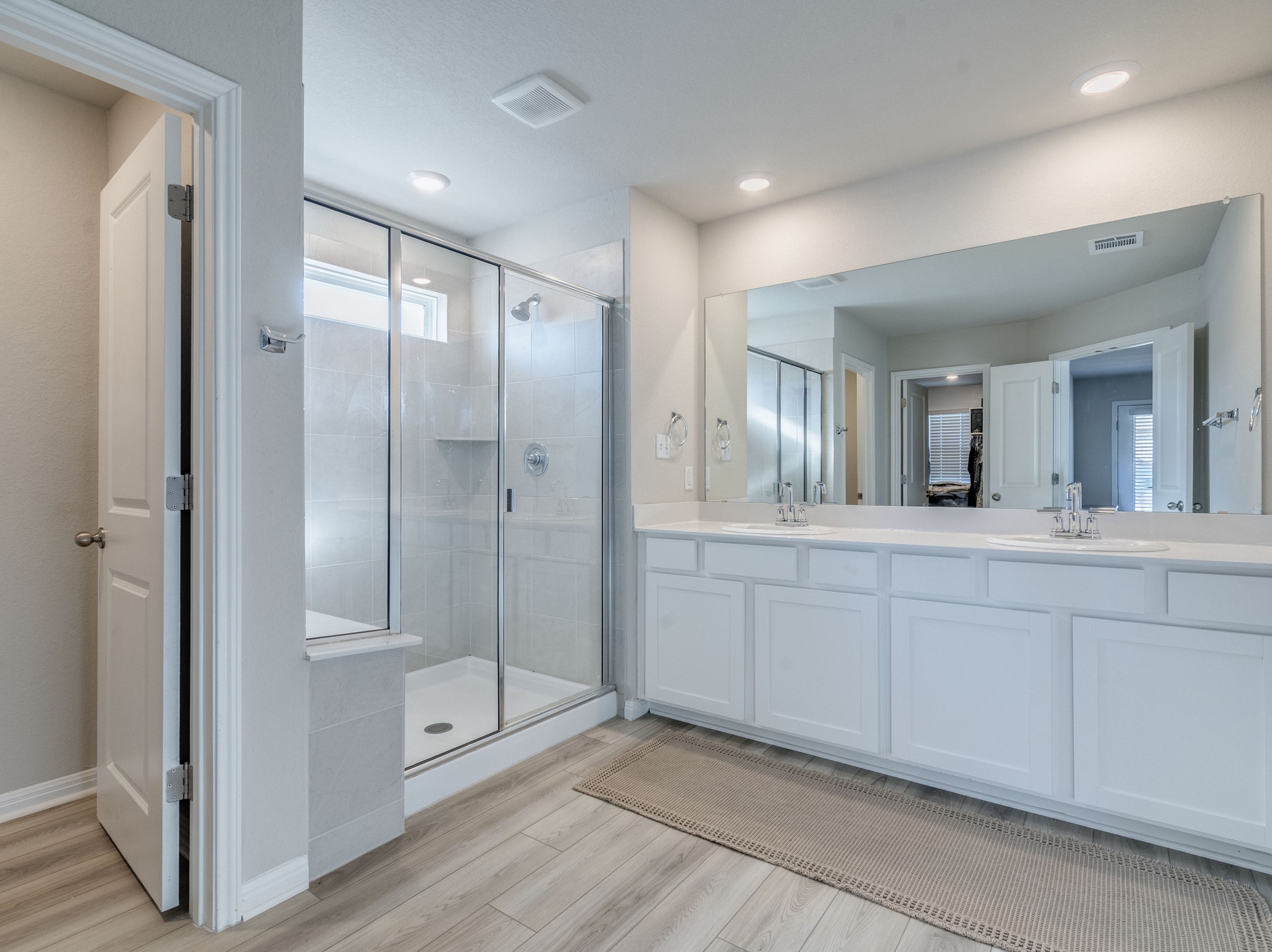 218 Glass Mountain Way Dripping Springs, TX 78620 - Photo 20 of 29 a spacious bathroom with a mirror a shower and vanity