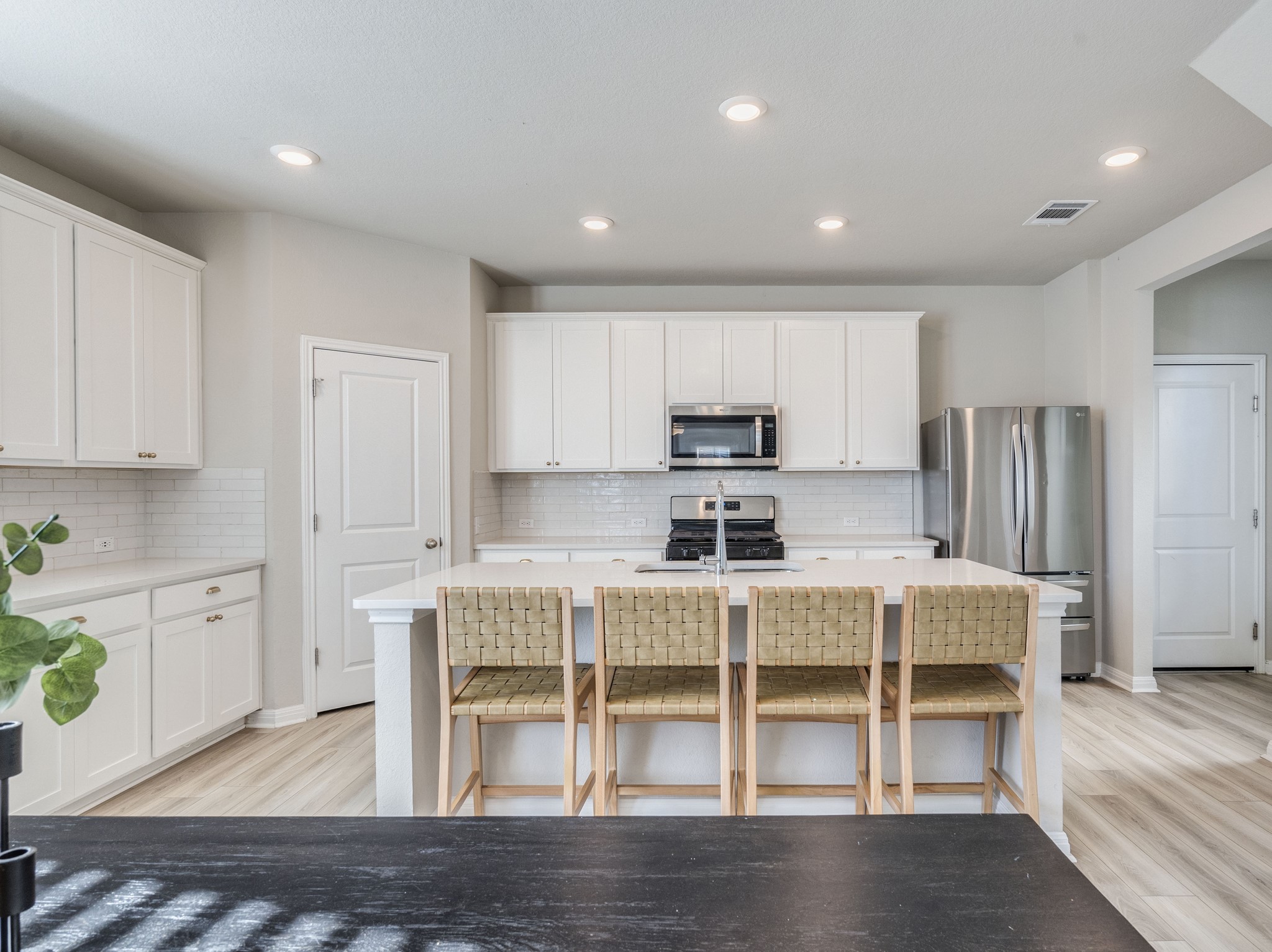 218 Glass Mountain Way Dripping Springs, TX 78620 - Photo 4 of 29 a view of kitchen with stainless steel appliances wooden floor and seating