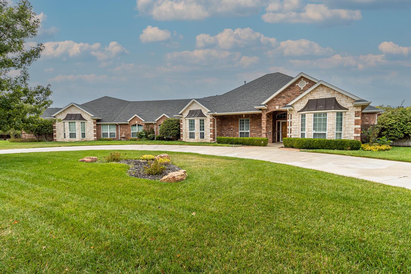 a view of house with a big yard and potted plants