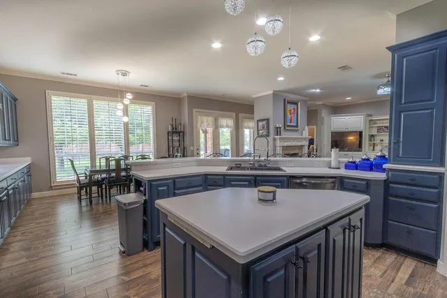 a kitchen with a stove a counter top space and a dining table with wooden floor