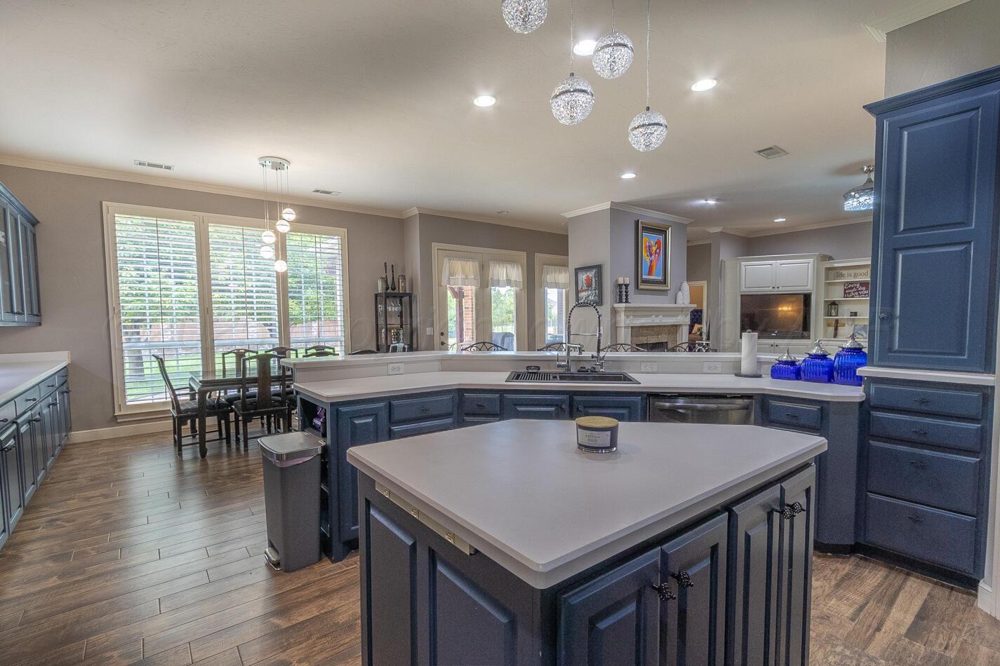 7500 Bayswater Road Amarillo, TX 79119 - Photo 11 of 46 a kitchen with a stove a counter top space and a dining table with wooden floor