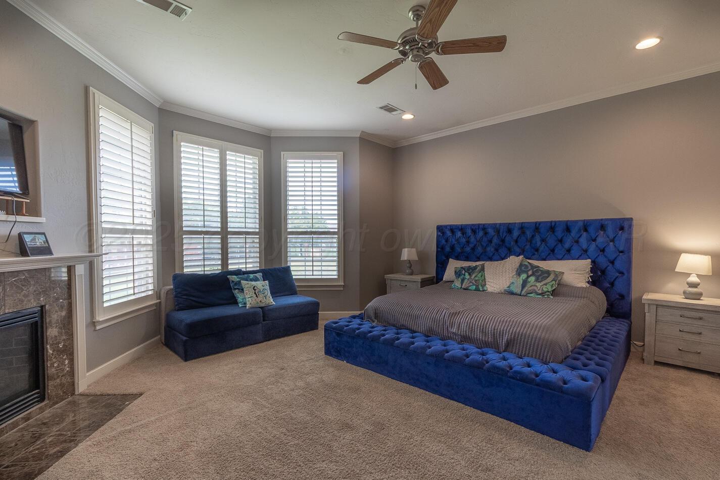 7500 Bayswater Road Amarillo, TX 79119 - Photo 13 of 46 a spacious bedroom with a bed a couch and windows