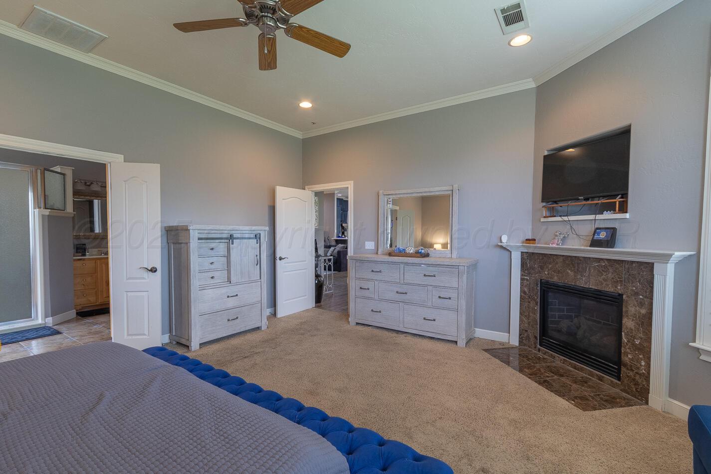 7500 Bayswater Road Amarillo, TX 79119 - Photo 14 of 46 a spacious bedroom with a bed and a flat screen tv