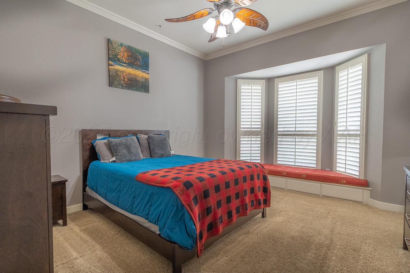 7500 Bayswater Road Amarillo, TX 79119 - Photo 20 of 46 a bedroom with a bed and a chandelier