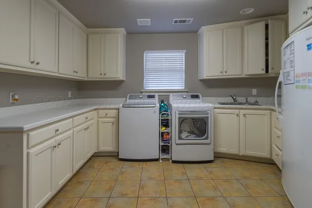 a utility room with cabinets washer and dryer