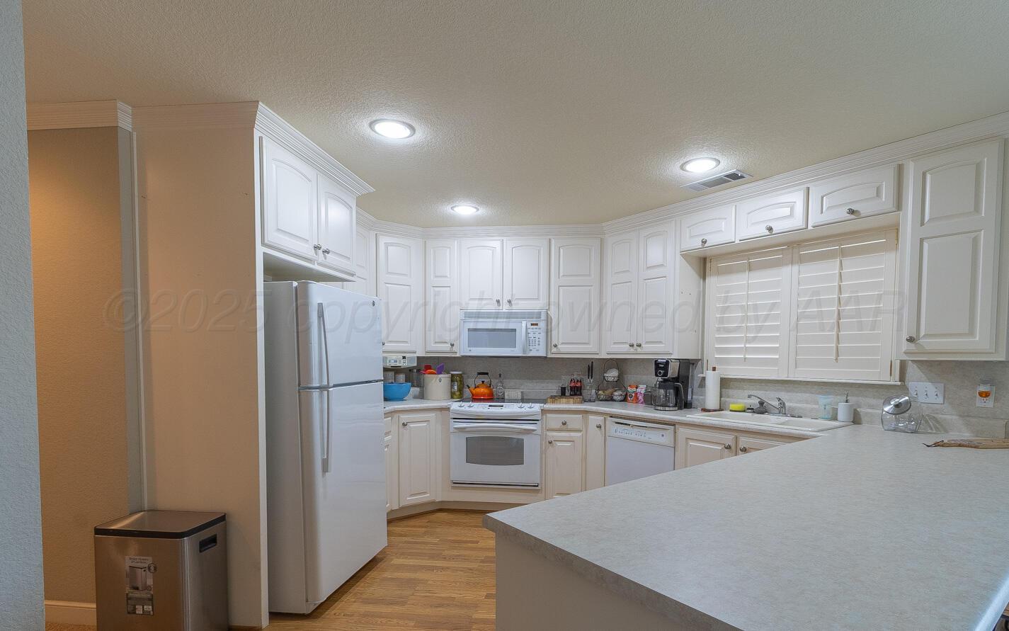 7500 Bayswater Road Amarillo, TX 79119 - Photo 29 of 46 a kitchen with a sink a refrigerator a window and cabinets