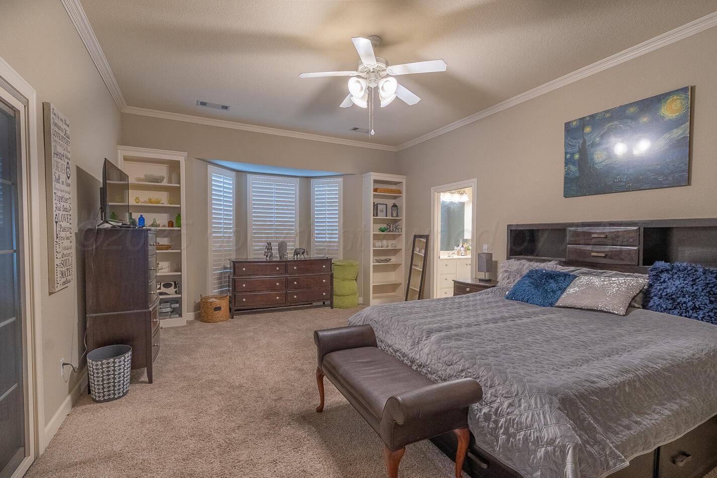 7500 Bayswater Road Amarillo, TX 79119 - Photo 30 of 46 a bedroom with a bed and a chandelier