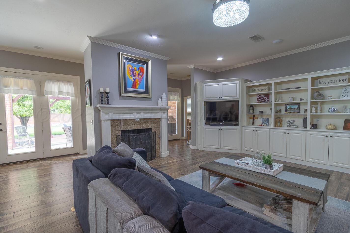 7500 Bayswater Road Amarillo, TX 79119 - Photo 8 of 46 a living room with furniture a flat screen tv and a fireplace