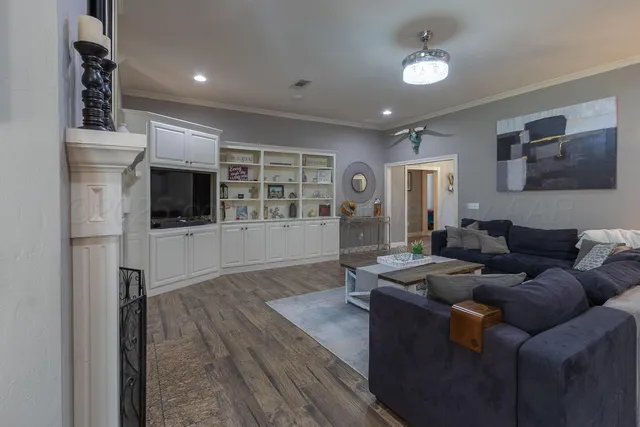 a living room with furniture a flat screen tv and kitchen view