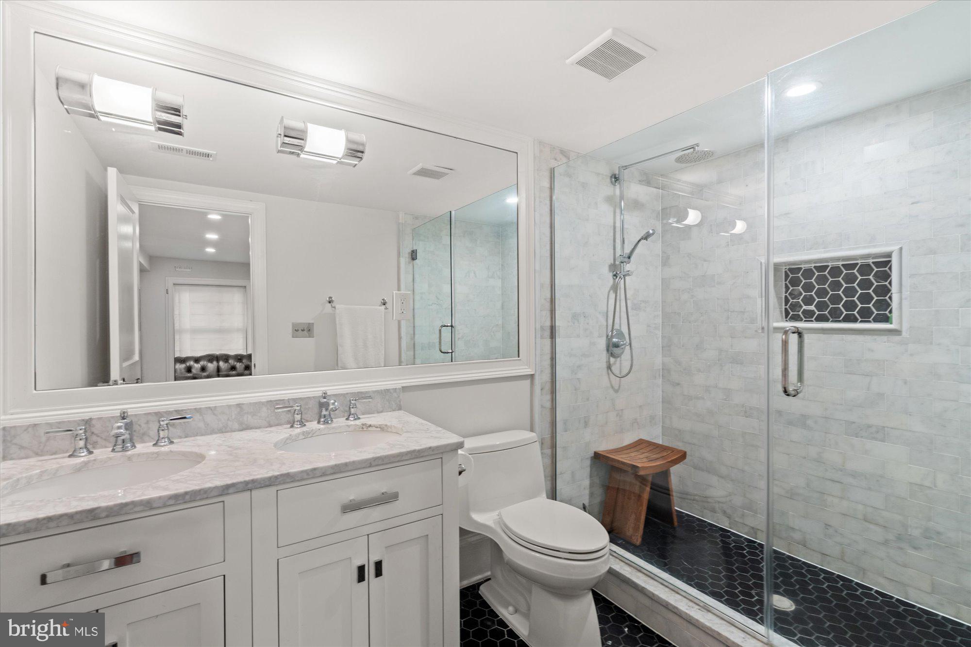 2610 Garfield Street Northwest Washington, DC 20008 - Photo 43 of 51 a bathroom with a granite countertop sink toilet a mirror a vanity and shower