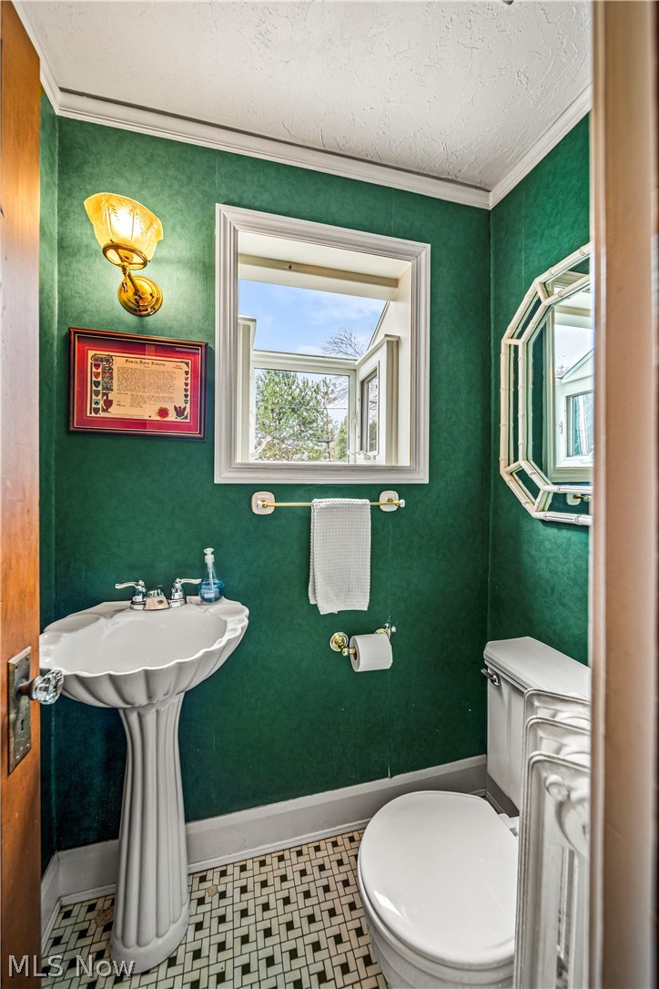 18000 Maplecliff Road Cleveland, OH 44119 - Photo 14 of 46 First floor powder room, featuring ornamental molding, toilet, and tile flooring
