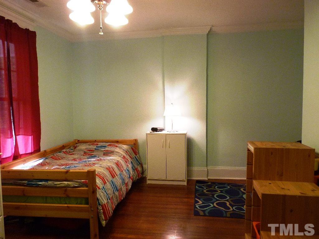 1324 Mordecai Drive Raleigh, NC 27604 - Photo 17 of 22 a bedroom with a bed and a chandelier