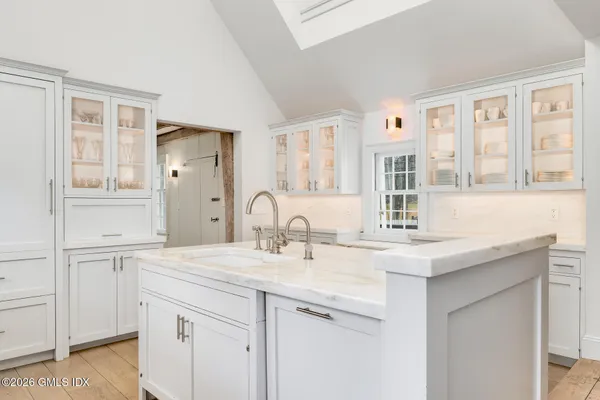 a kitchen with stainless steel appliances granite countertop a sink and cabinets with wooden floor